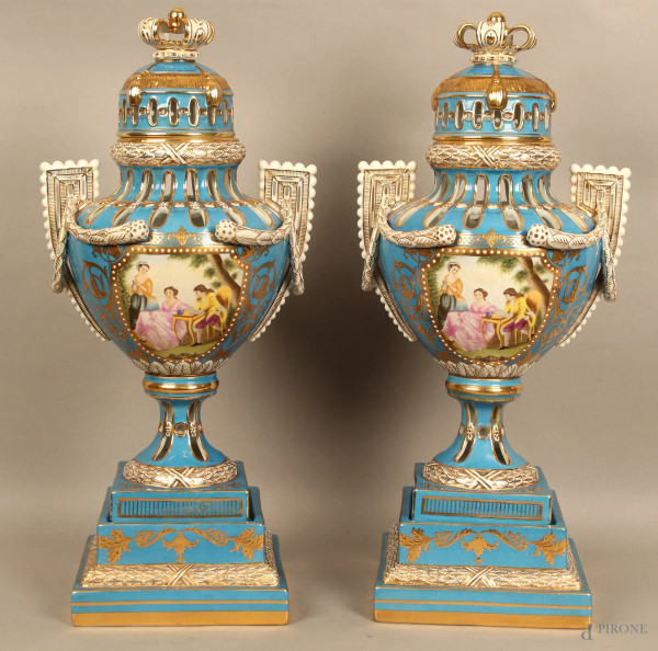 Coppia potiches in porcellana blu con medaglioni raffigurant scene galanti, particolari dorati, poggianti su basi h. 57 cm.
