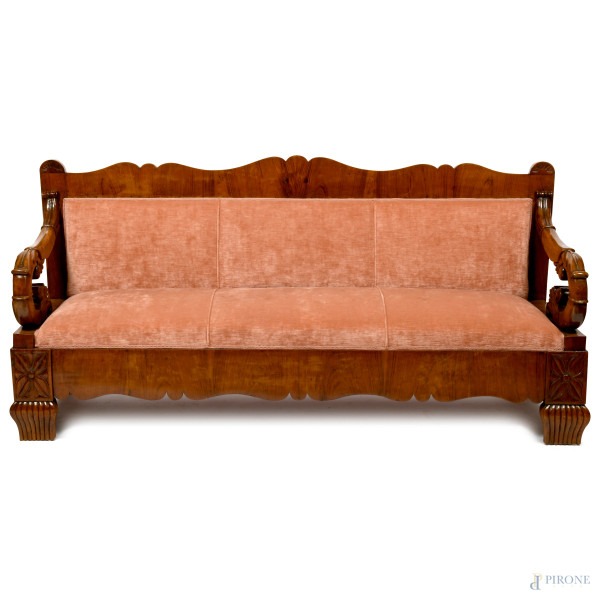Divano con struttura in noce con schienale sagomato e braccioli riccamente intagliati a volute. Piedi anteriori intagliati. Imbottito e rivestito in velluto, XIX secolo, cm 100x207x64, (scalfiture, difetti, segni di usura)