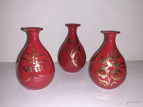 Lotto di tre vasetti in porcellana rossa con particolari dorati, h 9 cm.