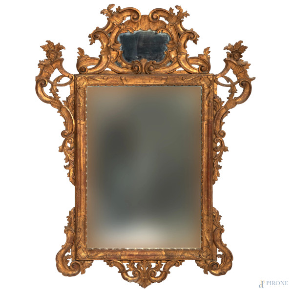 Specchiera in legno dorato e intagliato a volute ed elementi vegetali, XX secolo, cm 120x91, (segni di usura, rotture, difetti)