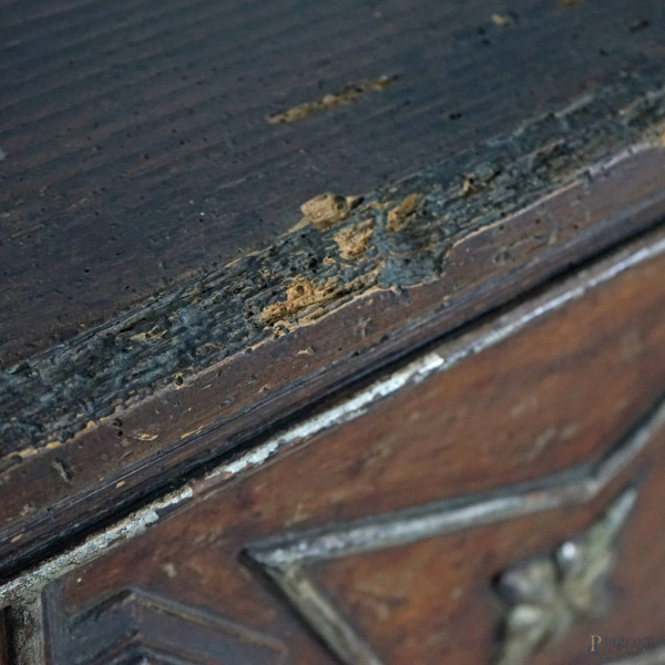 Cassone in legno tenero tinto a noce con fronte scolpito a motivi vegetali e geometrici dorati, g...