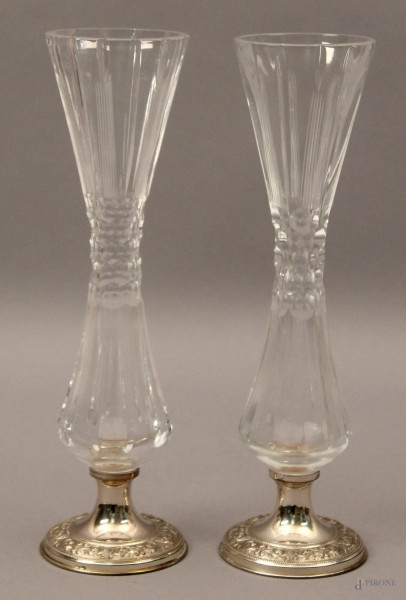 Coppia di vasetti portafiori in cristallo poggianti su basi in argento cesellato, H 26 cm.
