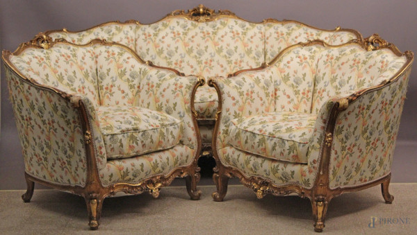 Salotto in legno dorato con particolari intagliati, rivestito in stoffa fiorata, composto da un divano e due poltrone, XIX sec.