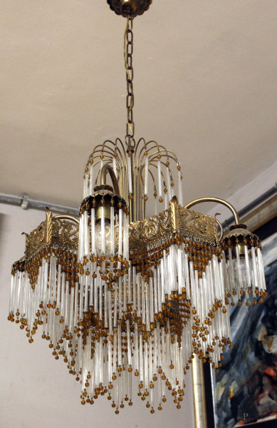 Lotto di un lampadario e due abat jour stile Liberty, in metallo dorato, pendenti in vetro e perle color ambra, altezza cm. 100, (piccoli difetti e mancanze).