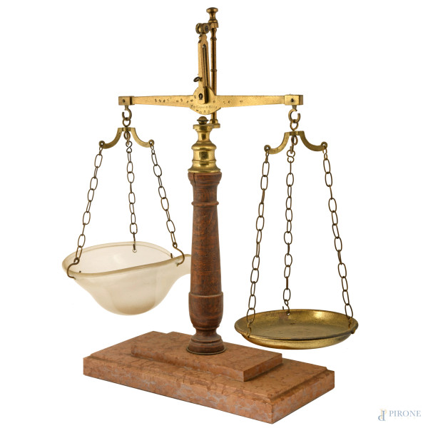 Grande bilancia a due piatti, uno in ottone e l'altro in vetro dal profilo mosso. Struttura compo...