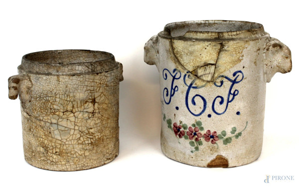 Lotto di due antichi vasi in ceramica smaltata con decori policromi, prese laterali a foggia di teste di arieti,  manifatture diverse, altezza max cm 24, (difetti e restauri).