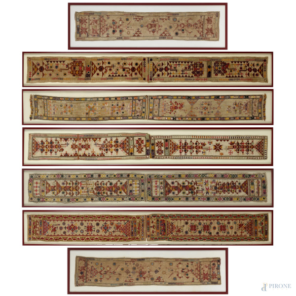 Lotto di sette tessuti ricamati mediorientali, XX secolo, misure massime cm 144x16,5 entro cornice