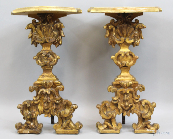Coppia di candelieri montati ad angolo, XIX secolo, in legno intagliato e dorato a motivi vegetali e rocailles, cm h 54x27x15,5 cadauno, (difetti).