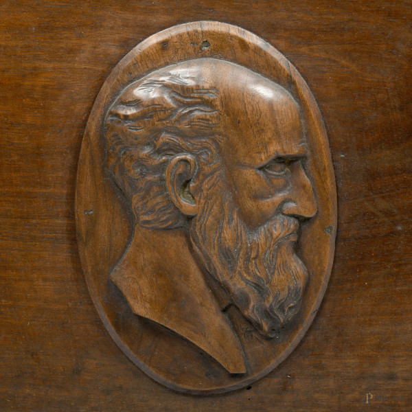 Cassapanca in noce modanato con fronte scandito da tre sezioni contenenti rispettivamente al cent...