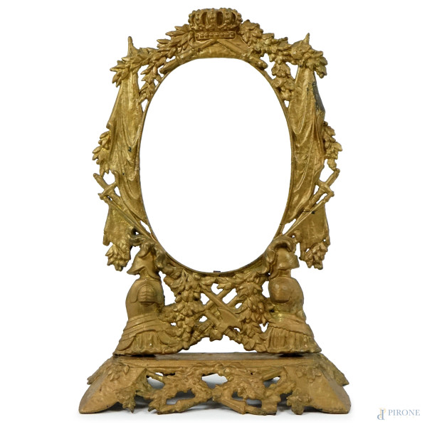 Cornice ovale in metallo dorato, decorata a rilievo con trofei militari e corona alla sommità, cm h 52x34,5x15,5, (difetti)