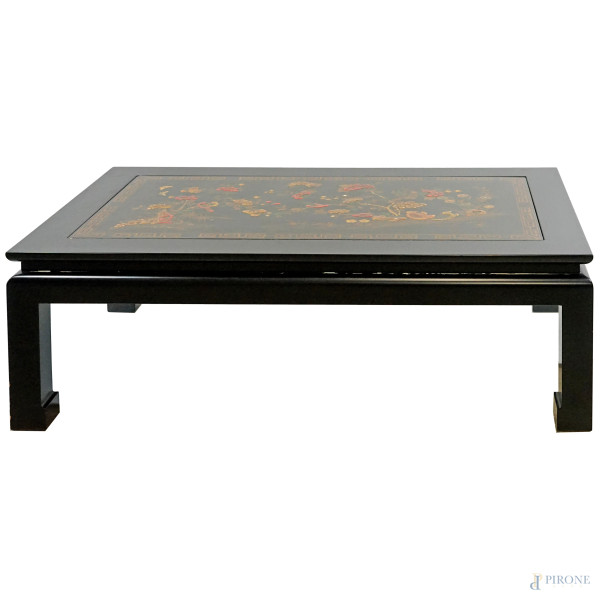 Tavolo basso in legno laccato nero, arte orientale, XX secolo, piano con pannello incassato decorato a rilievo, cm h 46x75x130, (difetti)