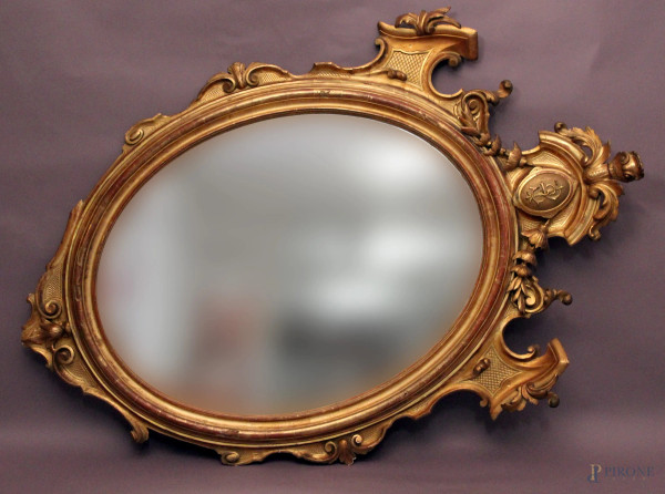 Specchiera di linea ovale in legno intagliato e dorato, (piccoli difetti), XIX sec., h. cm 177, larg. cm 118.