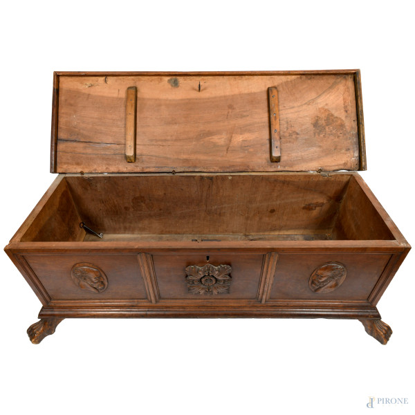 Cassapanca in noce modanato con fronte scandito da tre sezioni contenenti rispettivamente al cent...