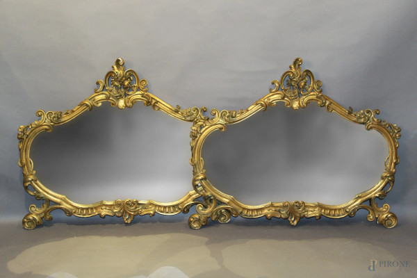 Coppia di specchiere di linea sagomata in legno dorato ed intagliato, XX sec., cm 85 x 102.