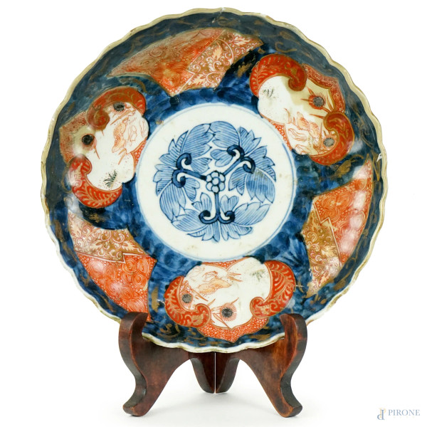 Piatto in porcellana Imari, decorato con motivi floreali in tre colori, blu, rosso e oro, diam. cm 21,5,  XX secolo, (difetti ed un restauro).