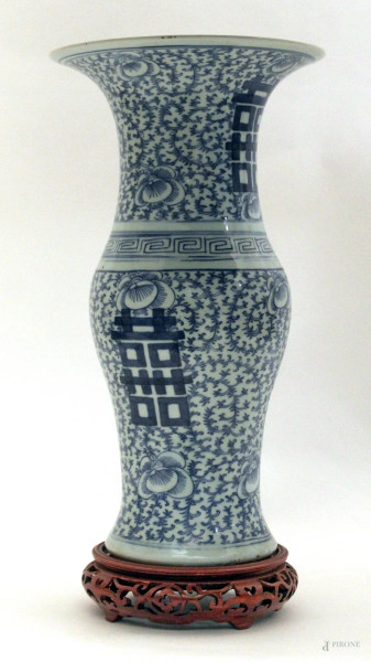 Vaso cinese in porcellana blu a decoro di ideogrammi e fiori, poggiante su base in legno, marcato,  XX sec., H. 39 cm.