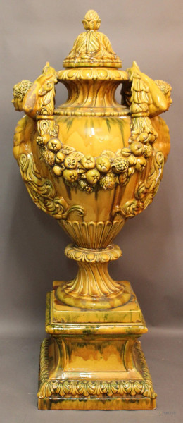 Grande potiche in maiolica smaltata gialla, anse a figure in rilievo e frutti, H 155 cm.