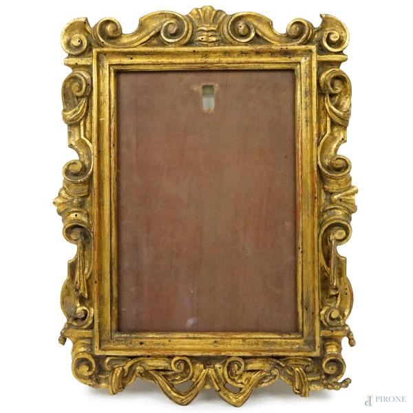 Cornice in legno intagliato e dorato, XX secolo, battuta scolpita a volute e nastri, misure ingombro cm 42,5x33, (difetti)