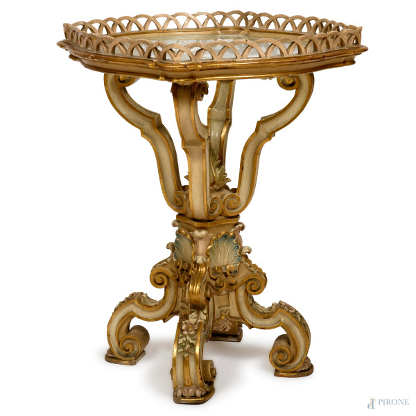 Tavolinetto in legno laccato e riccamente intagliato e traforato a volute, conchiglie e motivi floreali, piano in vetro, XX secolo, cm altezza cm 74 diametro cm 64, scalfiture, segni di usura, cadute di colore)
