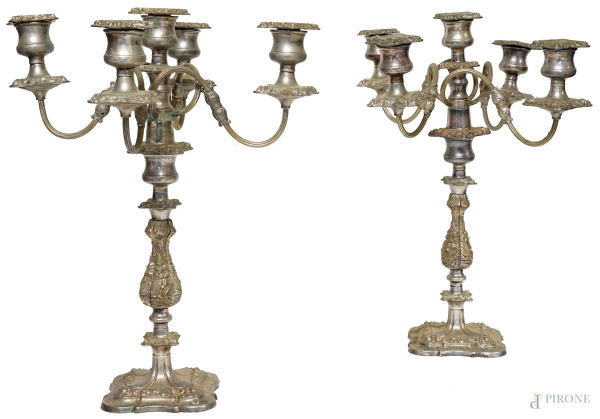 Coppia di candelabri in metallo argentato, metà XX secolo, bracci sinuosi, fusto a balaustro decorato a motivi floreali, poggiante su base quadrangolare, cm h 46, (difetti).