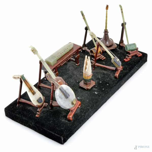 Composizione di 10 strumenti musicali in giada e pietre dure, Cina, XX secolo, cm12x32x14 (rottur...