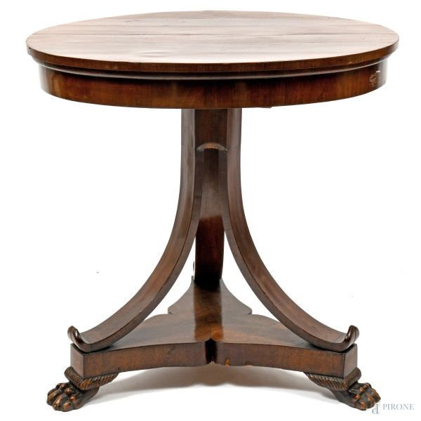 Tavolo circolare impiallacciato in noce con fusto diramato a triplice arco raccordato da pedana sorretta da piedi ferini, XX secolo, cm 80x32,5, (difetti)