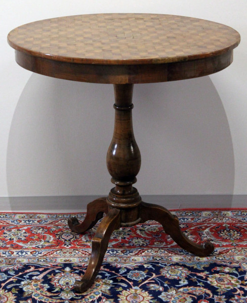 Tavolino di linea tonda in noce con intarsi geometrici, poggiante su colonna e tre piedi, diam. 70 cm, XIX sec.