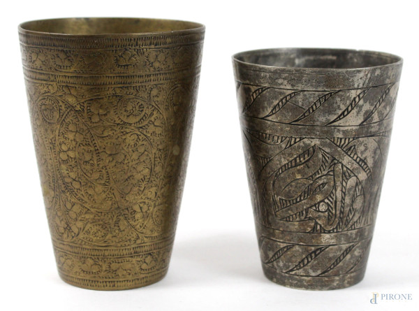Due bicchieri in metallo inciso a motivi vegetali, altezza max cm. 12,5, (difetti).
