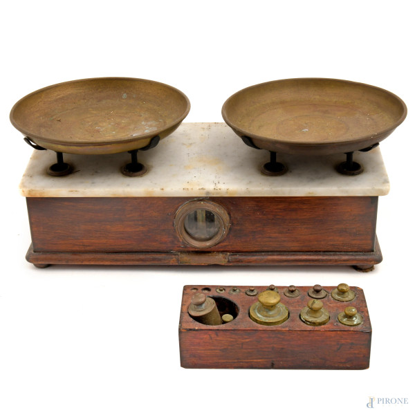 Bilancia meccanica a due piatti in ottone, montati su base rettangolare in legno con piano in marmo, XX secolo, cm 20x46x23, (difetti, da revisionare)