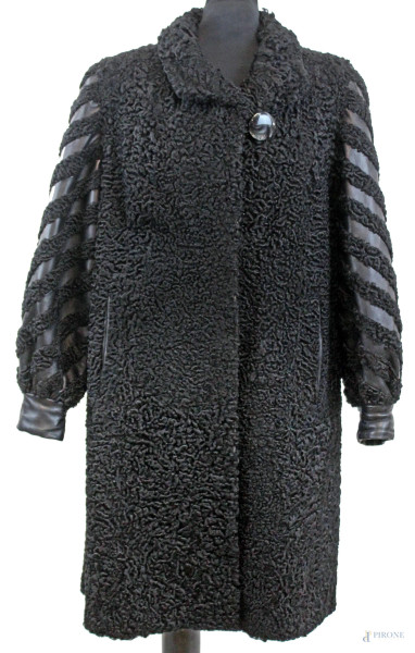 Cappotto da donna lungo nero in pelliccia sintetica, maniche con inserti in similpelle, due tasche esterne, chiusura con doppia clip ed un unico bottone, (segni di utilizzo).