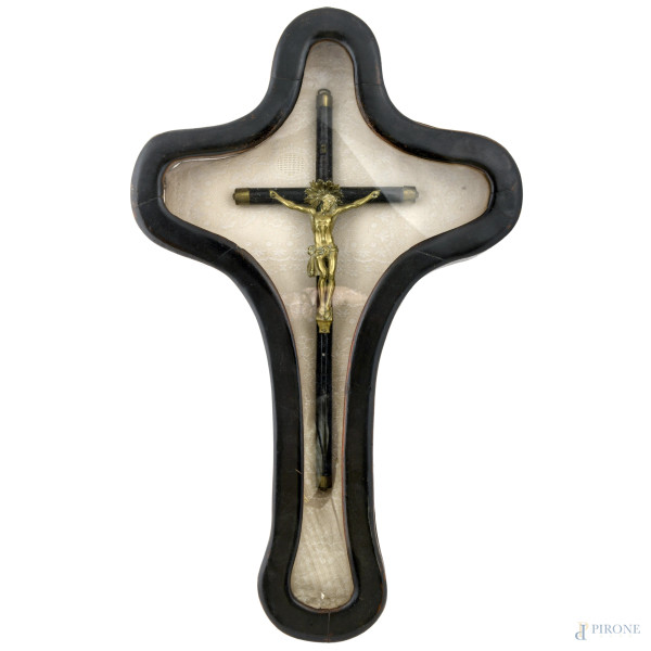 Crocifisso in legno ebanizzato e bronzo dorato applicato su supporto rivestito in tessuto entro cornice, XX secolo, misure complessive cm 63x39,5, (difetti)