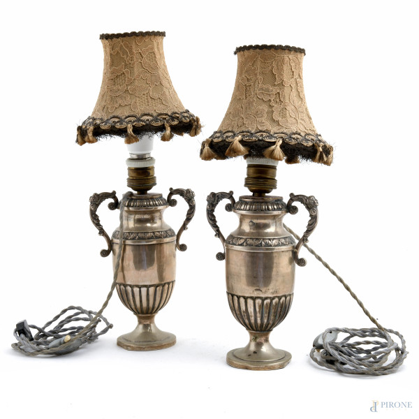 Coppia di lampade con base in argento 800/000, finemente cesellato con prese di ispirazione rinascimentale con volti femminili, XX secolo, altezza cm 40, peso lordo gr 1100 circa, (usura del tempo,  ammaccature, difetti, da revisionare)