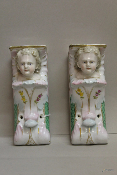 Coppia di mensoline in porcellana policroma con testine di bambini a rilievo marcate XIX sec, h.20 cm.