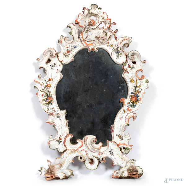 Specchiera in ceramica policroma decorata a volute e delfini, XIX secolo, cm 100x68, (segni di usura, sbeccature, rotture, difetti)