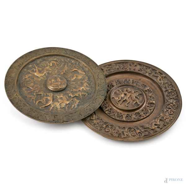 Lotto composto da due piatti decorativi a guisa di scudi in bronzo cesellato con battaglie e scene mitologiche, XX secolo, diametro massimo cm 23, (segni di usura)