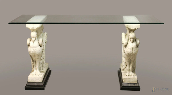 Tavolo con piano in cristallo sorretto da due basi in pasta cementizia raffiguranti fenici, h.82x180x80 cm