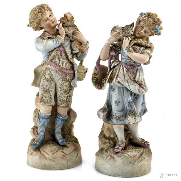 Coppia di sculture in biscuit raffiguranti fanciulli con cane e gatto, XX secolo, altezza massima cm 36, (segni di usura, difetti)