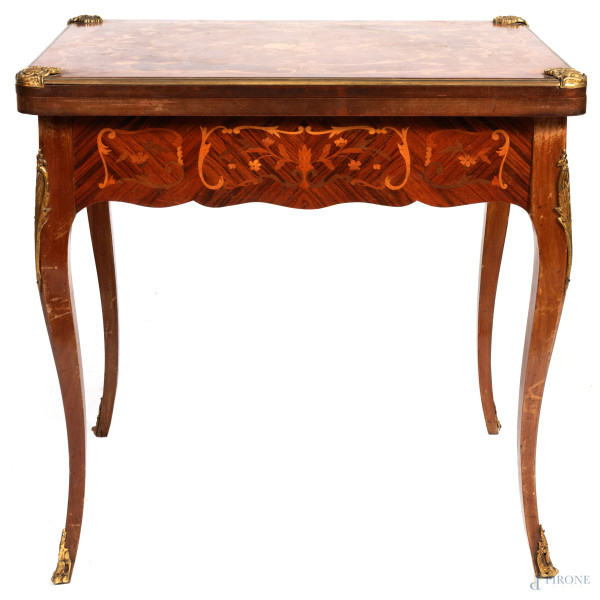 Tavolo da gioco in legno impiallacciato e intarsiato in vari essenze con inserti in bronzo dorato. XX secolo, misure aperto cm 72,5x114x77, misure chiuso cm 75,5x77x56 (segni di usura, difetti, scalfiture)