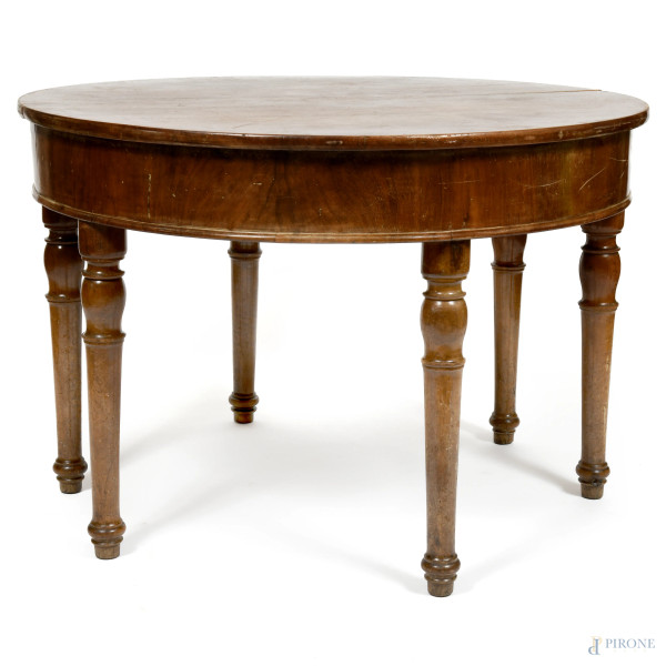 Tavolo allungabile in legno impiallacciato in piuma di mogano sostenuto da sei gambe tornite. XX secolo, cm 78x114x115. Due prolunghe cm 115x34 e una cm 116x49,5, (segni di usura, scalfiture, difetti)