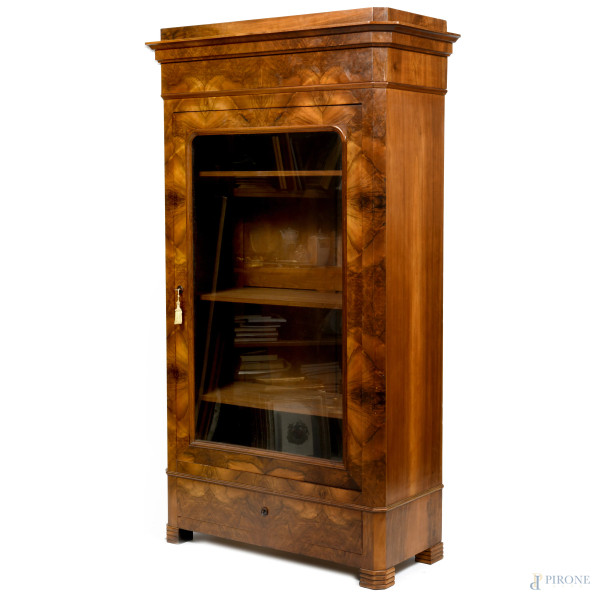 Mobile vetrina in legno impiallacciato in noce e radica di noce con anta singola e cassetto alla base. XX secolo, cm 204x118x52, (segni di usura, scalfiture, difetti)