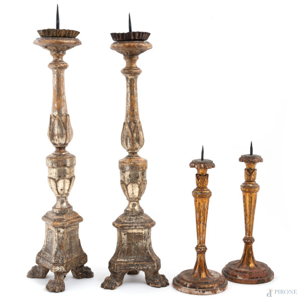 Lotto composto da due coppie di portaceri in legno intagliato, argentato e dorato, XX secolo, altezza massima cm 56, (segni di usura, scalfiture, cadute di doratura, argentatura)