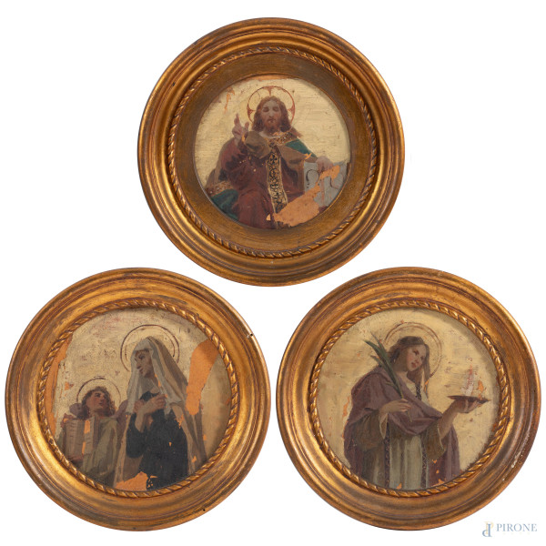 Lotto di tre dipinti ad olio su cartone in serto circolare raffiguranti Cristo tra Sante, XIX-XX secolo, diametro cm 21,5, entro cornice, (cadute di colore, abrasioni)