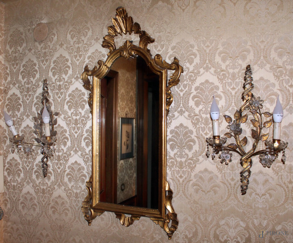 Lotto composto da uno specchio in legno intagliato e dorato, h. cm 103 e due appliques in ferro battuto con prismi in vetro, h. cm 52.