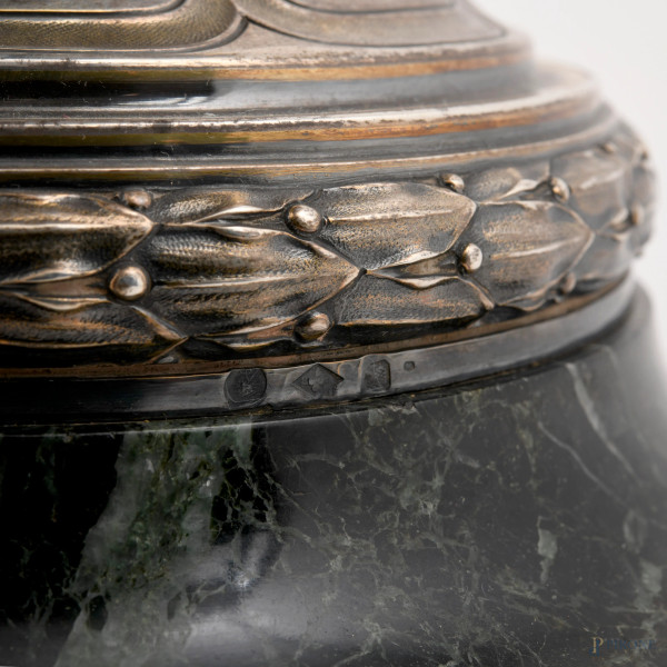 Grande vaso biansato in argento con prese a guisa di putti su foglie d'acanto a sorreggere l'orlo...