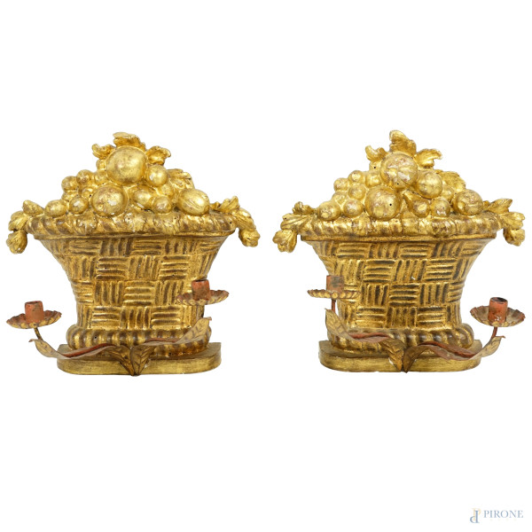 Coppia di applique in legno intagliato e dorato a forma di canestra di frutta, con due bracci porta candela in ferro battuto, XX secolo, cm 23x25