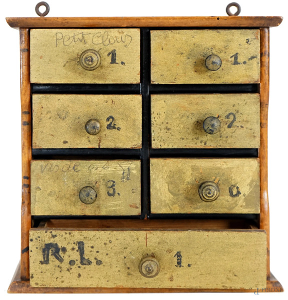 Piccola cassettiera da farmacia in noce a sette cassettini dorati, XX secolo, cm 22x22x9, (difetti).