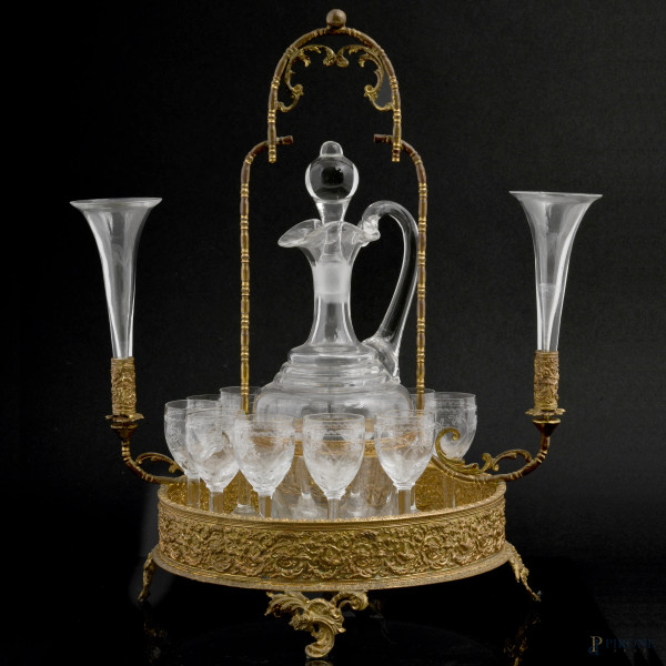 Servizio da liquore composto da versatoio e 11 bicchierini in vetro inciso entro struttura in metallo dorato finemente cesellato, XX secolo, cm 34x26x20