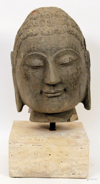 Testa di budda, scultura in pietra poggiante su base in travertino, H 30 cm.