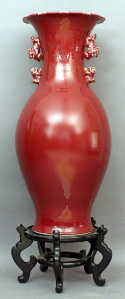 Grande vaso in porcellana, color sangue di bue con due cani di foo laterali, altezza 82 cm, poggiante su base in tek, Cina XX secolo.