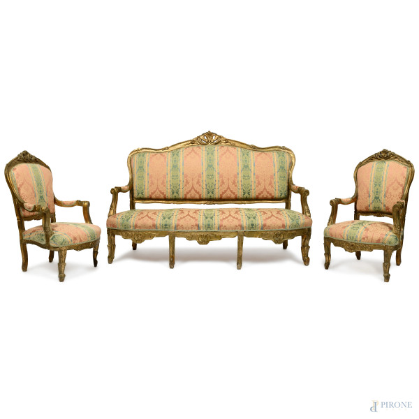 Lotto composto da coppia di poltrone e divano in legno intagliato e dorato, con sedute, braccioli e schienale in tessuto policromo a motivi floreali, XIX-XX secolo. Poltrone cm 118x70,5x70,5 ca. Divano cm 122,5x178x67 ca. (segni di usura, scalfiture, fessurazioni, restauri, fori di tarlo)